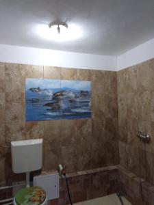 baño con aseo y una pintura en la pared en Casa Garden Wellness, en Eforie Nord