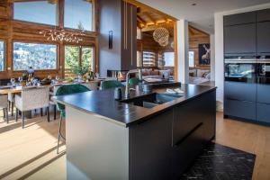 a kitchen with a large island and a dining room at Chalet Bella Cha - OVO Network in La Clusaz