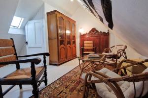 uma sala de estar com cadeiras de baloiço e uma mesa em Ti va zud kozh em La Feuillée