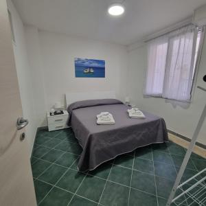 トッレ・デル・オルソにあるCasa Vacanze AFEA Torre dell'Orso Salento Pugliaのベッドとタオル2枚のある寝室