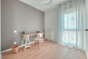 Jest to biały pokój z biurkiem i oknem. w obiekcie OVELIA Rennes Chantepie - Le Patio Margot w mieście Chantepie