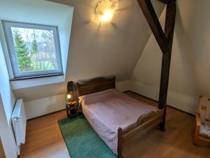 niewielka sypialnia z łóżkiem i oknem w obiekcie Noclegi U Lestka w mieście Lutowiska