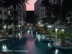 a swimming pool in a city at night at The Room Arun in Hua Hin