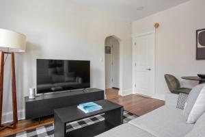 a living room with a couch and a flat screen tv at Bright Brighton 1BR near T Shops BOS-775 in Boston