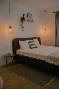 a bed with two pillows and a table in a room at Sibiu City Lights in Şura Mare