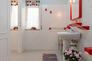 bagno bianco con lavandino e doccia di "A CASA COGONI - OSPITALITÀ e CULTURA" a Monserrato
