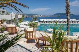 a swimming pool with tables and chairs and the ocean at Mirada Exclusive Bodrum in Bodrum City