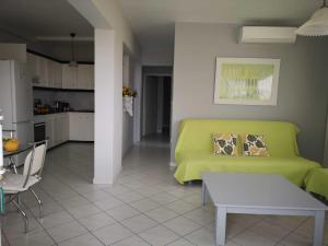 a living room with a green couch and a kitchen at Apartments Jasu in Kivérion