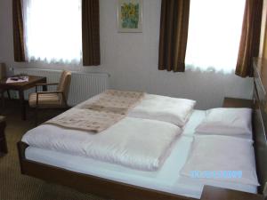 a bedroom with two beds and a table and windows at Gasthaus Waldhorn in Bad Teinach-Zavelstein
