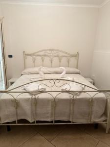 uma cama branca com lençóis brancos e almofadas em Casa vacanze Conte Cavour em Laterza