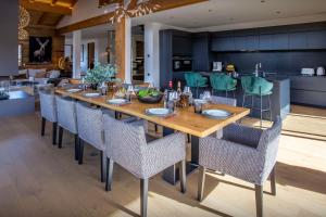 a dining room with a long wooden table and chairs at Chalet Bella Cha - OVO Network in La Clusaz