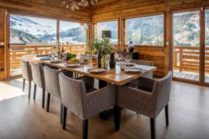 a dining room with a long table and chairs at Chalet Bella Cha - OVO Network in La Clusaz