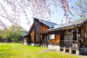 una gran casa de madera con un patio de césped en Nature Cottage Akabeko, en Kitashiobara