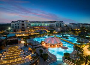 a resort with a large swimming pool at night at Kaya Palazzo Golf Resort in Belek