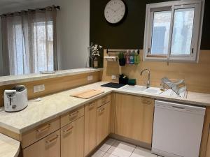 a kitchen with a sink and a clock on the wall at La cave à Papé in Peyriac-de-Mer +9 photos