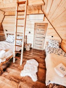 a bedroom with two bunk beds and a ladder at Wood Szczęścia in Korczyna