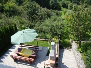 eine Terrasse mit einem Sonnenschirm, Stühlen und einem Tisch in der Unterkunft Apartments Maroflin in Crni Lug