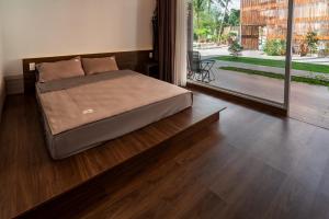 1 dormitorio con 1 cama en el suelo de madera en Homestay Papa garden, en Pleiku