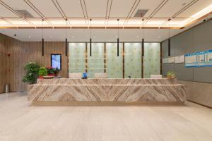 a lobby with a reception desk in a building at Morning Hotel, Wuxi Jiangnan University Sunac Cultural Tourism City in Wuxi