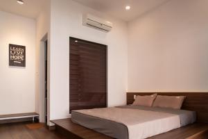 a bedroom with a bed with a wooden headboard at Homestay Papa garden in Pleiku