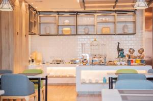 a restaurant with tables and chairs in a kitchen at Morning Hotel, Wuxi Jiangnan University Sunac Cultural Tourism City in Wuxi