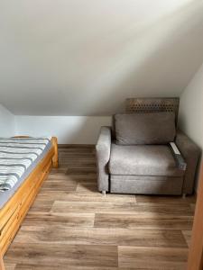 1 dormitorio con 1 cama y 1 silla en Unstrut Hütte, en Bad Langensalza