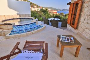 a patio with a table and a chair and a fire pit at Çınarlar Apart KC Blok in Kas