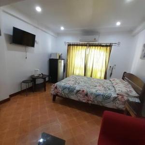 a bedroom with a bed and a window and a television at Niran Grand Ville A4F in Pattaya Central