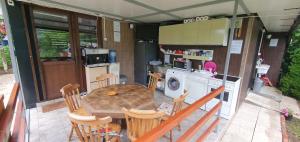 eine Küche und ein Esszimmer mit einem Tisch und Stühlen in der Unterkunft Kamp kućica trokrevetna in Crnča