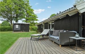 SkattebølleにあるNice Home In Tranekr With 3 Bedrooms, Sauna And Wifiの木製デッキ(椅子、テーブル付)