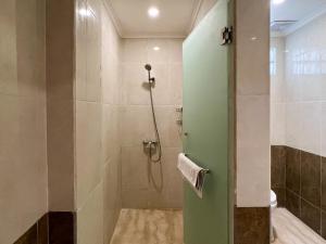 a bathroom with a shower with a green door at Grand Istana Rama Hotel in Kuta