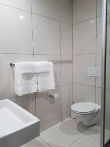 a white bathroom with a toilet and a sink at Movic's Modern Airbnb in Windhoek