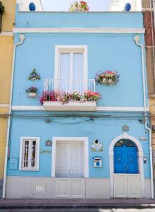 une maison bleue avec deux portes et deux fenêtres dans l'établissement La Casa di Nonna Piera, à Giardini Naxos