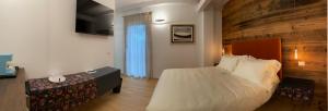 a bedroom with a large bed and a wooden wall at Cruna di Subida Wine Country House in Cormòns