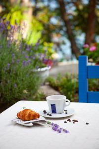 a cup of coffee and a croissant on a table at ADIS Holiday Inn Hotel in Golden Sands