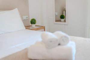 um quarto com uma cama branca e um espelho em Stamatia Suites em Asprovalta