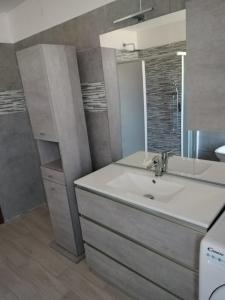 ein Bad mit einem Waschbecken und einem Spiegel in der Unterkunft Villa Chiara in Marina di Sorso