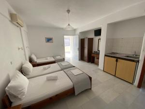 a bedroom with a large bed and a kitchen at Asiminas in Naxos Chora