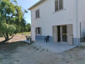 ein weißes Gebäude mit einem Tisch neben einem Baum in der Unterkunft Villa Chiara in Marina di Sorso