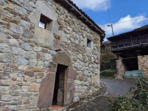 un edificio de piedra con una puerta en el costado en Casa La Parra en Villar de Vildas