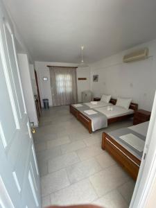 a large bedroom with two beds and a window at Asiminas in Naxos Chora