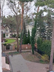 ein Park mit Bäumen und ein Haus im Hintergrund in der Unterkunft Apartamencik przy Tężni w Konstancinie in Konstancin-Jeziorna