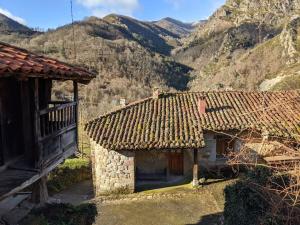 una casa vieja con una montaña en el fondo en Casa La Parra, en Villar de Vildas