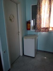 a small white refrigerator in a room with a window at Panorama Rooms in Kyllini