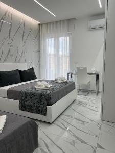 una camera con letto e parete in marmo di White Elegance Luxury B&B Caserta a Caserta