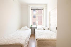 2 camas en una habitación blanca con ventana en 2ndhomes Bright 2BR Apartment next to Esplanade Park, en Helsinki