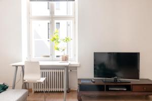 a living room with a flat screen tv on a table at 2ndhomes Bright 2BR Apartment next to Esplanade Park in Helsinki
