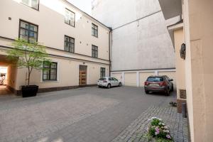 two cars parked in a parking lot next to a building at 2ndhomes Bright 2BR Apartment next to Esplanade Park in Helsinki