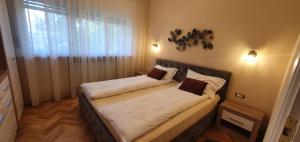 a bedroom with a bed with white sheets and a window at Dream Apartment Timisoara in Timişoara