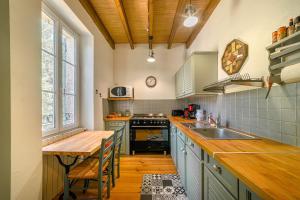 cocina con mesa de madera y fregadero en La Maison de Beaugas - Avec piscine dans le pays des bastides, en Beaugas